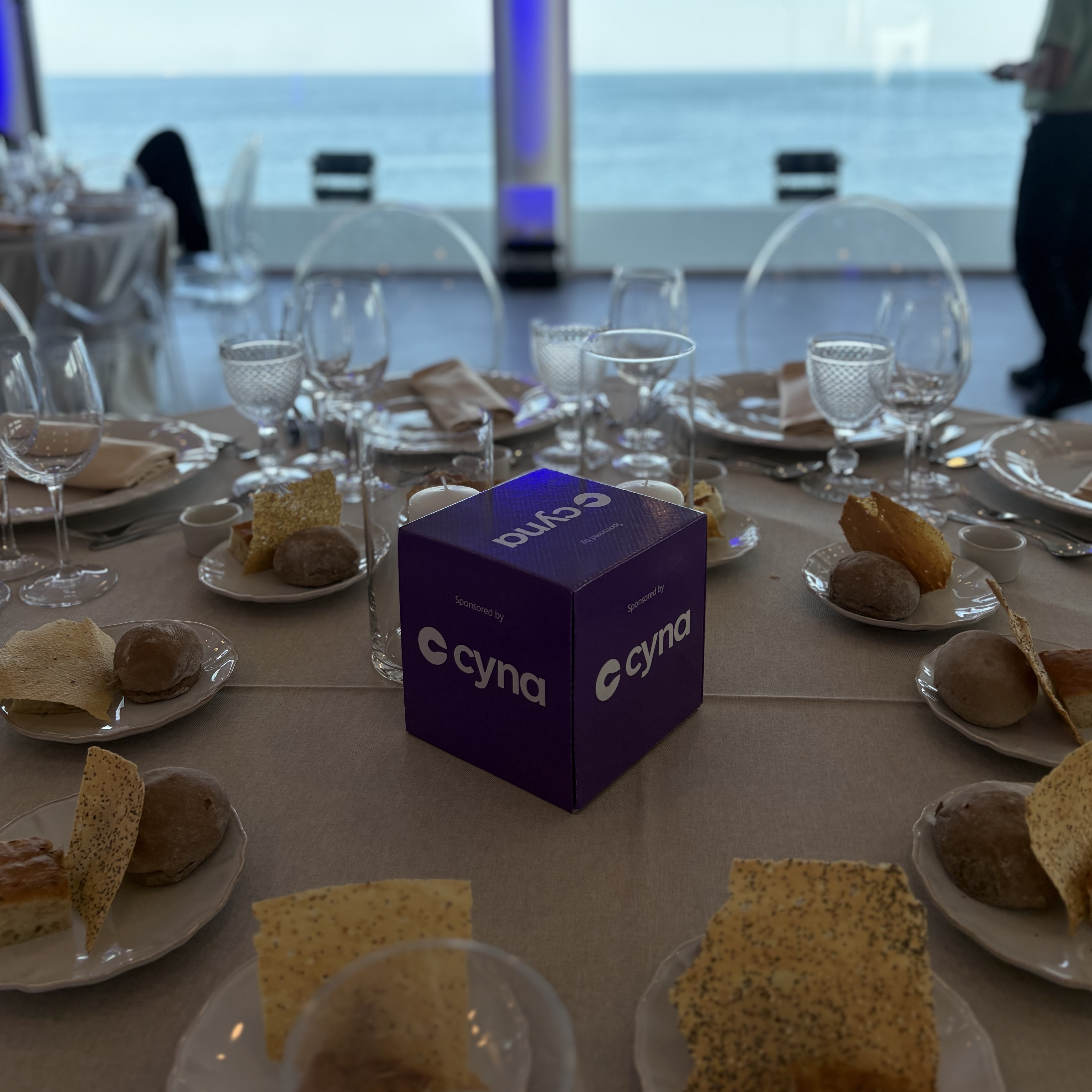 Networking dinner at the Microsoft Security Executive Partner Connect EMEA in Cascais, with a Cyna-branded cube as a table centrepiece facing the sea